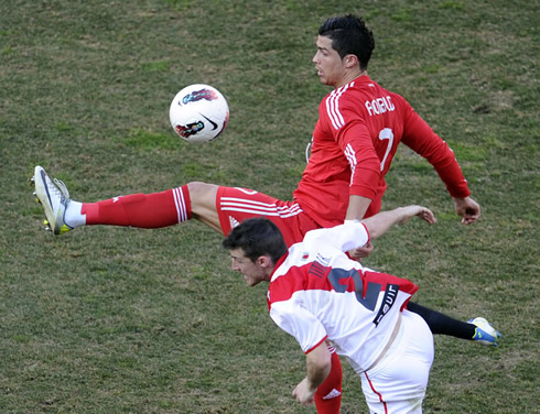 Cristiano Ronaldo with his left leg raised, trying to control the ball in a Real Madrid game