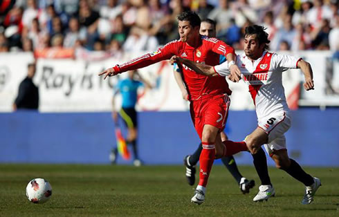 Cristiano Ronaldo sprinting and fighting for the ball in a Real Madrid match in 2012
