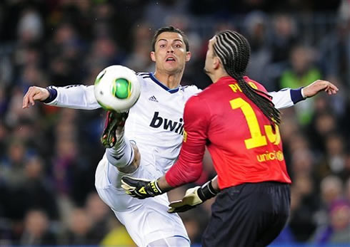 Cristiano Ronaldo stretching his right leg to attempt to reach the ball before Barcelona's goalkeeper, Pinto, in the Copa del Rey clash in 2013