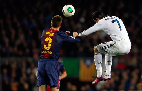Cristiano Ronaldo jumping higher than Gerard Piqué and about to head the ball in the Clasico, at the Camp Nou