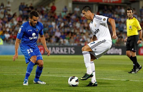 Cristiano Ronaldo preparing to dribble a defender in a Real Madrid game in 2012