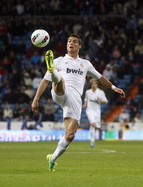 Cristiano Ronaldo stretches his right leg to attempt to reach the ball