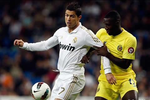Cristiano Ronaldo protects the ball, using his arms to avoid the defender to reach it