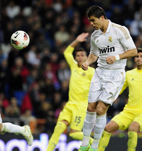 Cristiano Ronaldo jumps and heads the ball while defenders are already claiming for off-side