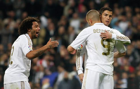 Cristiano Ronaldo hugging Karim Benzema while Marcelo approaches