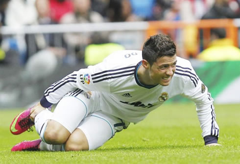 Cristiano Ronaldo complaining about a knock on his right foot, holding to his ankle in pain