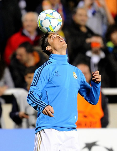 Cristiano Ronaldo in a blue Real Madrid training jersey, juggling with the UEFA Champions League ball