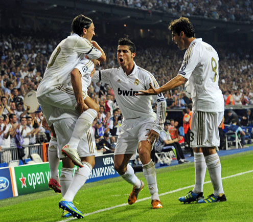 Cristiano Ronaldo in a weird pose, celebrating a goal with his teammates in the UEFA Champions League