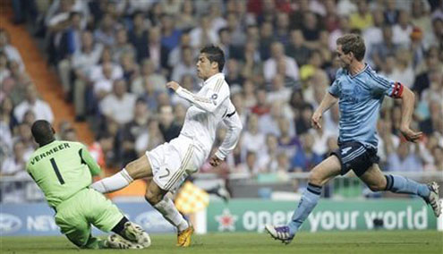 Cristiano Ronaldo trying to reach the ball before Ajax goalkeeper in the UEFA Champions League 2011-2012 edition