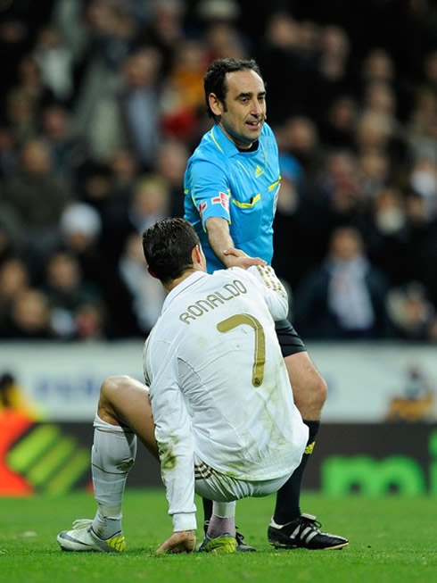 Cristiano Ronaldo standing up with a little help from the referee, in Real Madrid vs Zaragoza