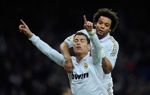 Cristiano Ronaldo points his two fingers to the sky and closes his eyes when celebrating a goal for Real Madrid, while Marcelo climbs to his back