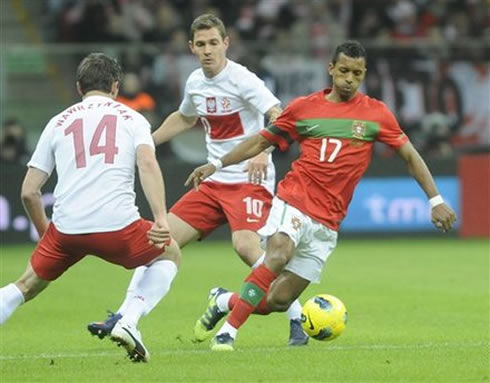 Nani dribbles between two Polish defenders, in Portugal vs Poland, in 2012
