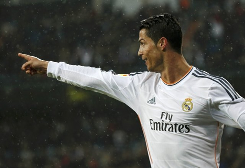 Cristiano Ronaldo stretching his arm and pointing at a teammate