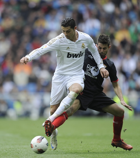 Cristiano Ronaldo trying to protect the ball from being stolen by a Sevilla defender