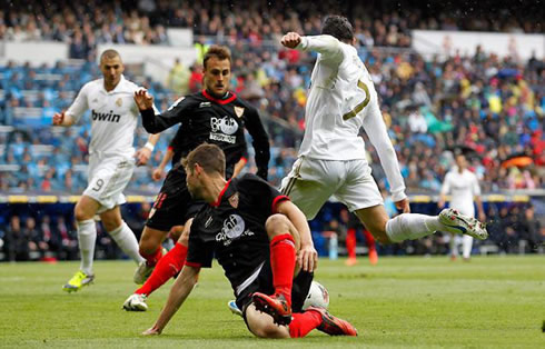 Cristiano Ronaldo dribbling a defender and preparing to strike and score in Real Madrid vs Sevilla, for La Liga, in 2012