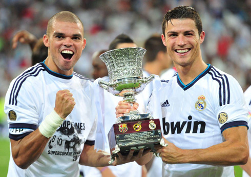Cristiano Ronaldo and Pepe smiling and taking a photo holding the Spanish Supercup trophy won against Barcelona, in 2012-2013