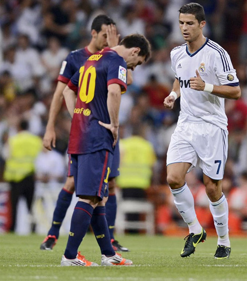 Lionel Messi looking down as Cristiano Ronaldo runs by him, in Real Madrid 2-1 Barcelona, in 2012