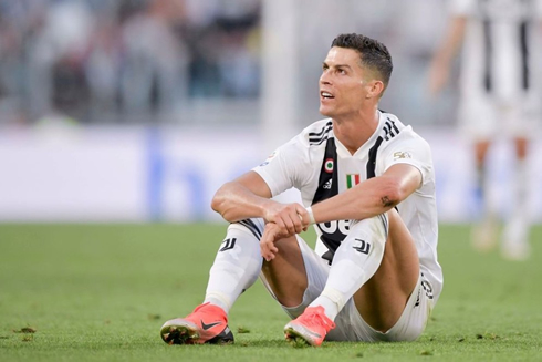 Cristiano Ronaldo sits on the grass to rest for a while