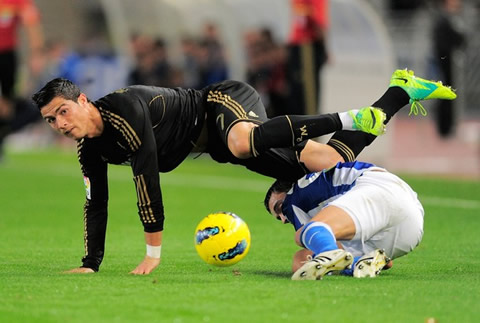 Cristiano Ronaldo gets tackled and but doesn't let the ball get out of his sight