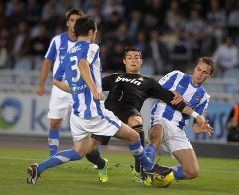 Cristiano Ronaldo tries to reach the ball with opposition from two defenders