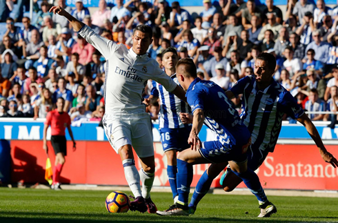 Cristiano Ronaldo dribbling two defenders in a league match between Deportivo Alavés and Real Madrid