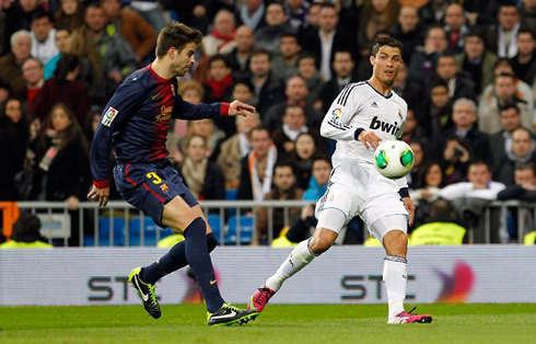 Cristiano Ronaldo making a cross with his left foot, as Gerard Piqué watches from distance, in Copa del Rey 1st Leg, in 2013