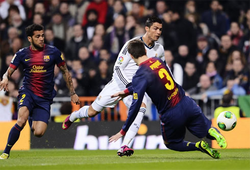 Cristiano Ronaldo dribbling Gerard Piqué, with Daniel Alves witnessing it a few meters behind, in Clasico 2013