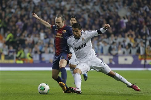 Cristiano Ronaldo pushing Andrés Iniesta as they fight for the ball, in a Clasico between Real Madrid and Barcelona at the Santiago Bernabéu, in 2013