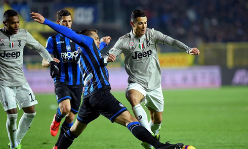 Cristiano Ronaldo tries to dribble an Atalanta player in their cup game in 2019