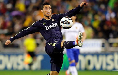 Cristiano Ronaldo stretching out his leg to reach the ball, showing off his flexibility skills in Real Madrid 2013