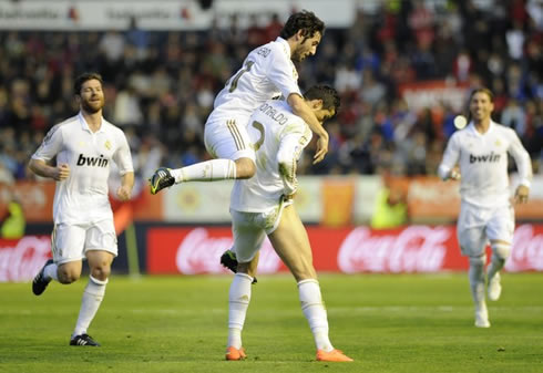 Cristiano Ronaldo with Granero on his back, pulling his shorts up to show his right leg muscles after scoring a goal in Osasuna vs Real Madrid in 2012