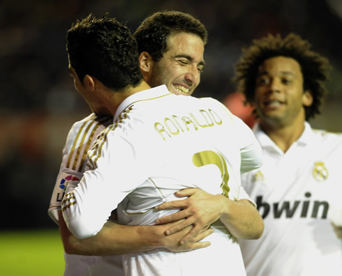 Higuaín smiling and showing his teeth as he hugs Cristiano Ronaldo and Marcelo gets near them