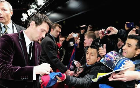 Messi signing an autograph at a Barcelona shirt/jersey in FIFA's Balon d'Or 2011 event