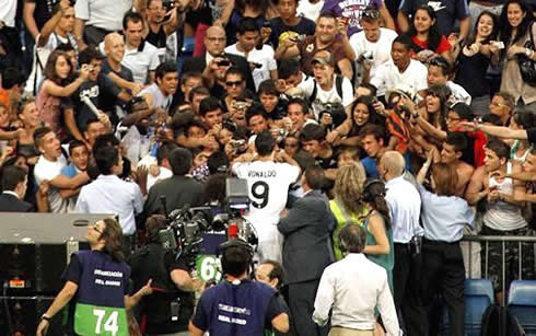 Cristiano Ronaldo signing autographs to fans in the crowd, in the Santiago Bernabéu