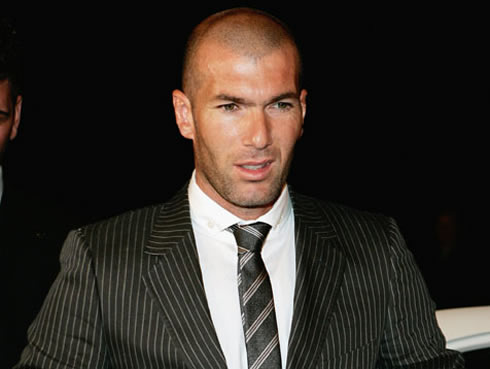 Zinedine Zidane bald but hot, wearing a suite with stripes and a tie