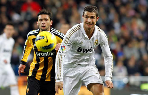 Cristiano Ronaldo in a big effort, making a funny and strange face, while Hélder Postiga runs behind him, during a Real Madrid vs Zaragoza match in 2012