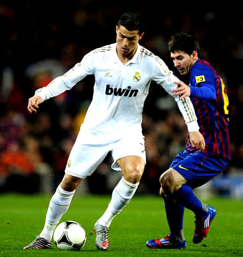 Lionel Messi trying to steal the ball from Cristiano Ronaldo, in a Barcelona vs Real Madrid Clasico, in 2011-2012