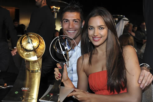 Cristiano Ronaldo and Irina Shayk taking a photo holding Ronaldo's two awards