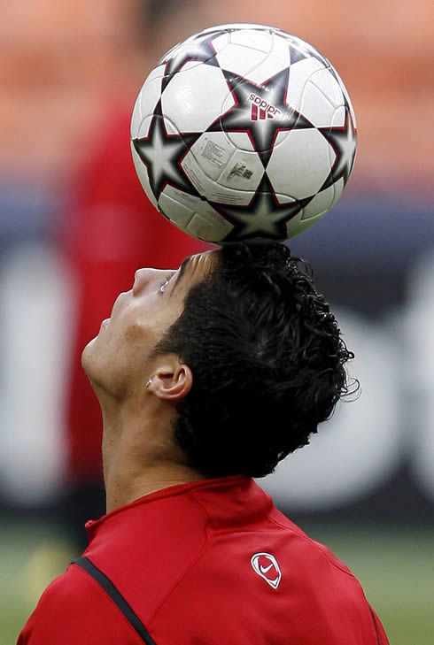 Cristiano Ronaldo holding the ball on his forehead, at a Manchester United warm-up