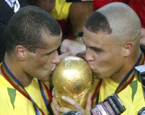 Rivaldo and Ronaldo kissing the World Cup trophy, that they won for Brazil, in 2002