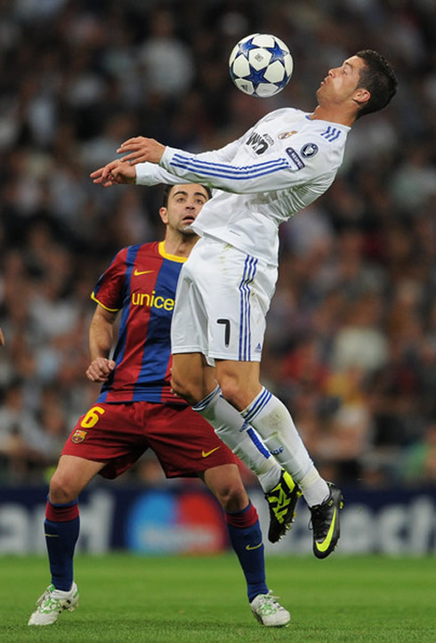 Cristiano Ronaldo chest control, with Xavi Hernandez watching, in Real Madrid vs Barcelona in 2010/2011