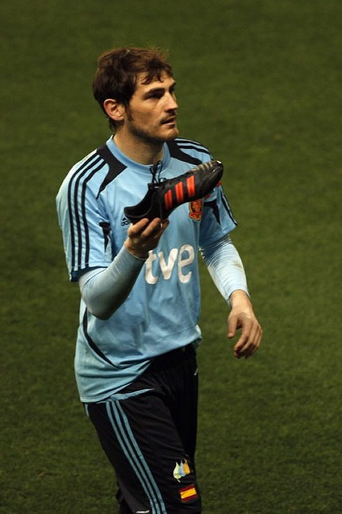 Iker Casillas looking lost, as he holds a soccer boot