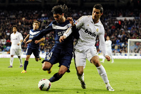 Cristiano Ronaldo body balance against a Malaga defender in La Liga 2012