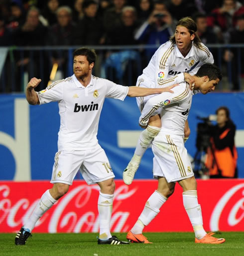 Cristiano Ronaldo holding with Sergio Ramos on his back, while Xabi Alonso calls for more teammates to join the celebrations in 2012