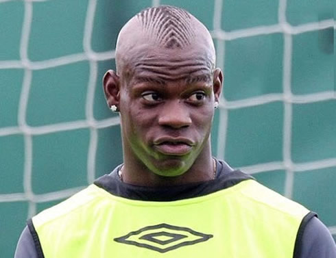 Mario Balotelli funny and awkward face and haircut/hairstyle, in Manchester City, with his vest put backwards