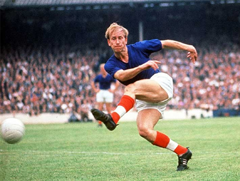 Bobby Charlton playing for Manchester United, in a blue jersey, between 1956-1973