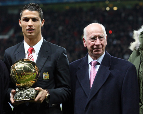 Sir Bobby Charlton next to Cristiano Ronaldo, holding the FIFA Balon d'Or 2008, at Old Trafford