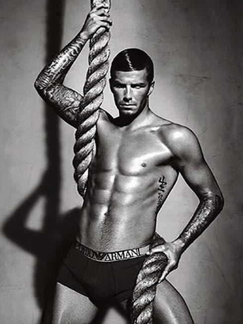 David Beckham in Armani photoshoot, shirtless and holding a rope as he shows his six pack abs