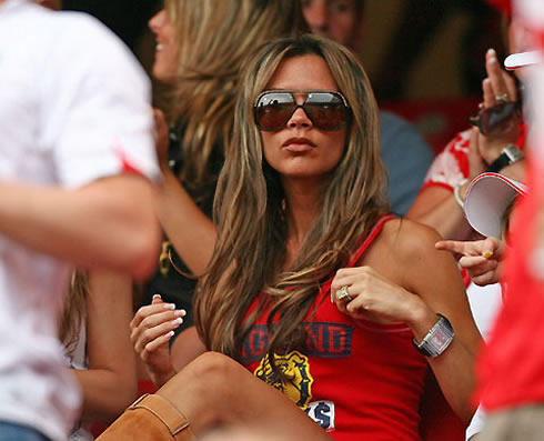 Victoria Beckham, wearing sunglasses and looking hot and sexy in an England top and brown boots