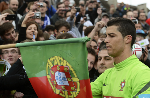 Cristiano Ronaldo signing his name autograph in a Portuguese flag, in the EURO 2012